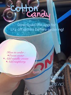 a person holding up a cup with cotton candy in it and an ad for cotton candy