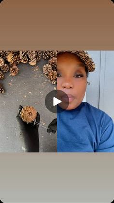 a young boy wearing a hat with pine cones on top of his head and in front of him