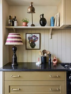 a kitchen with an oven, lamp and other items on the counter top in front of it