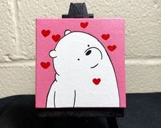 a small white polar bear with hearts on it