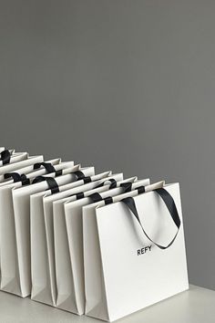 a row of white bags with black handles