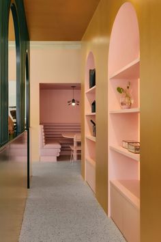 the hallway is lined with pink and gold shelving, along with a white dining room table