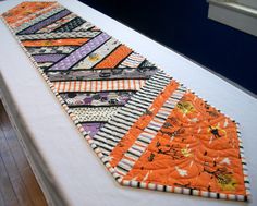 an orange and black patchwork table runner