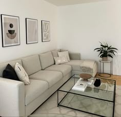 a living room with a couch, coffee table and pictures on the wall