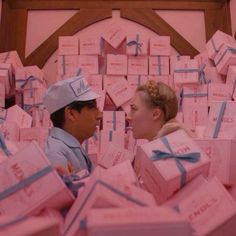 a man and woman surrounded by pink boxes