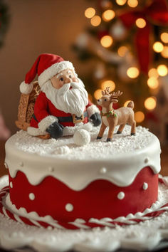 a christmas cake decorated with santa claus and reindeer figurines