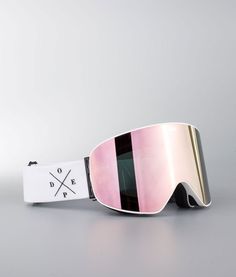 a pair of ski goggles sitting on top of a white table next to a tag