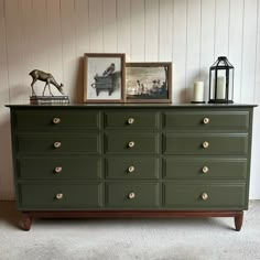 a green dresser with pictures and candles on top