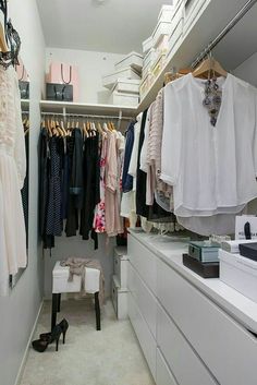 an organized closet with clothes and shoes on the shelves, drawers, and hanging racks