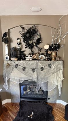 a living room decorated for halloween with black and white decorations on the fireplace mantel