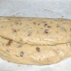 two uncooked pizza doughs sitting on top of each other