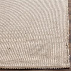 a beige rug on top of a wooden floor