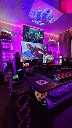 a gaming room with two computer monitors, keyboard and video game controllers on the desk