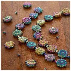 some colorful buttons are laying on a wooden table and one has been cut into smaller pieces