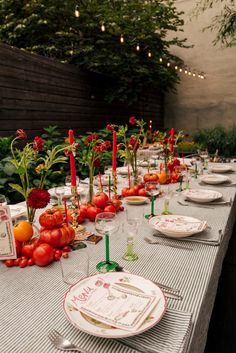 a long table is set with plates and place settings for an outdoor dinner or party