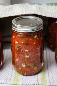 jars filled with pickles sitting on top of a table