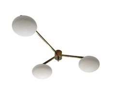 three white balls are hanging from a brass chandelier on a white background,