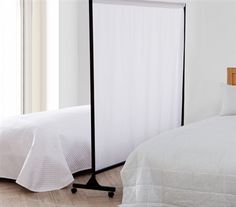 a white bed sitting next to a wooden headboard on top of a hard wood floor