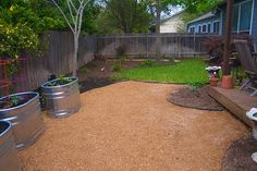 a back yard with several buckets on the ground