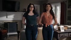 two women standing next to each other in a living room