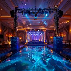 an indoor swimming pool is lit up with blue lights and draping on the ceiling