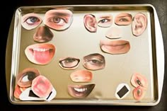 a metal tray topped with lots of cut out faces