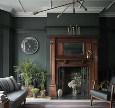 a living room filled with furniture and a clock on the wall above a fire place