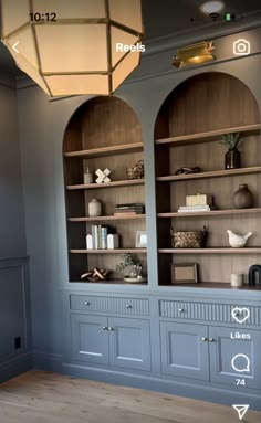 a room with two blue bookcases and a light fixture above the bookshelf