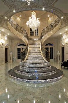 a grand staircase with chandelier in the middle and marble steps leading up to it