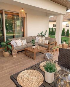 an outdoor living area with wicker furniture and potted plants