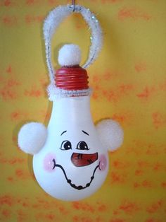 a white light bulb with a face painted on it's side hanging from a hook