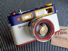 a camera sitting on top of a bed next to a tag