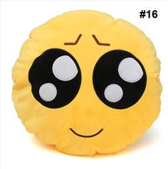 a yellow smiley face pillow with black eyes and two white dots on it's forehead