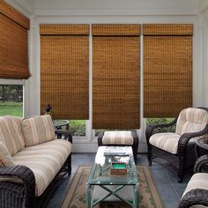 a living room filled with furniture and covered in bamboo blind shades on the windowsill