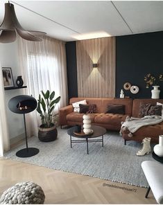 a living room filled with lots of furniture next to a large window covered in curtains