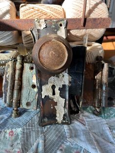 an old rusty door handle and knobs on a piece of cloth with other items in the background