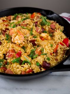 a skillet filled with rice and shrimp