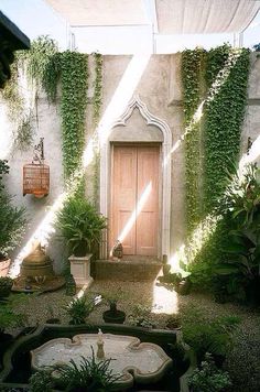 an outdoor courtyard with potted plants and a fountain