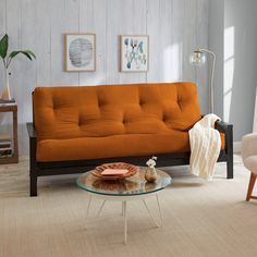 a living room with two chairs and a futon couch in the middle of it