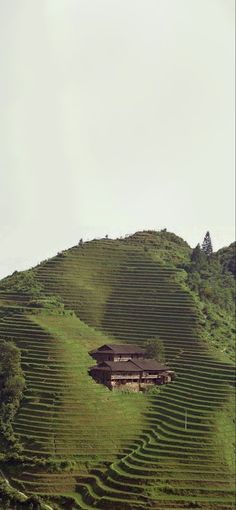 a house on the side of a hill with grass growing all over it's sides