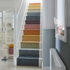 the stairs are lined with different colored carpeted stairs in this home's entryway