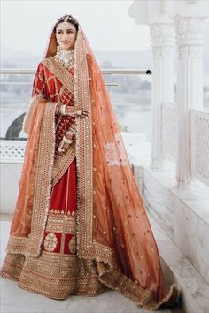 a woman in an orange and red bridal outfit