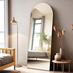 a bedroom with a large mirror on the wall next to a small bed and side table