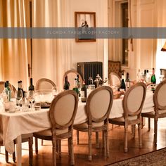 a dining room table is set up with wine bottles and glasses on the top tables