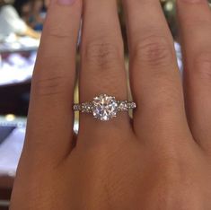 a woman's hand with three stone engagement ring on top of her left hand