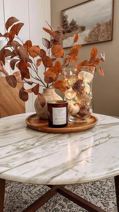 a marble table topped with a vase filled with flowers and candles on top of it