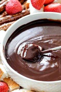 a chocolate dip in a white bowl with strawberries on the side