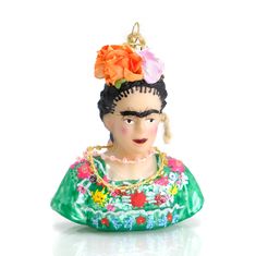 a ceramic figurine with a flower in her hair, wearing a green dress