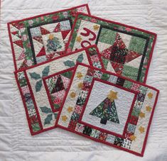 four quilted placemats with christmas trees on them and the number twenty five