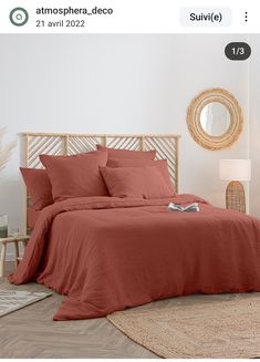 a bed with red sheets and pillows in a room